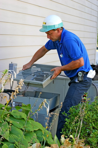 technician working on outside unit of an air conditioner