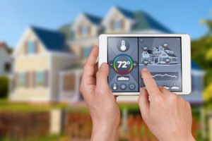 smart-thermostat-in-forefront-with-house-in-background