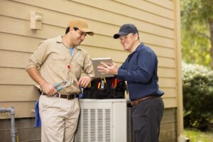 Technicians discussing heat pump maintenance service during a commercial HVAC preventative maintenance visit.