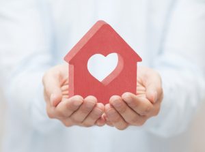 hands-holding-house-with-heart-cutout